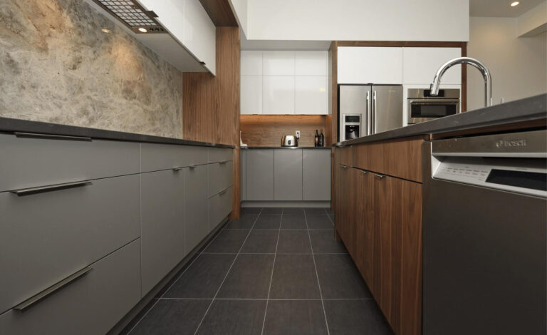 Contemporary kitchen featuring gray cabinets and wooden accents with stainless steel appliances.