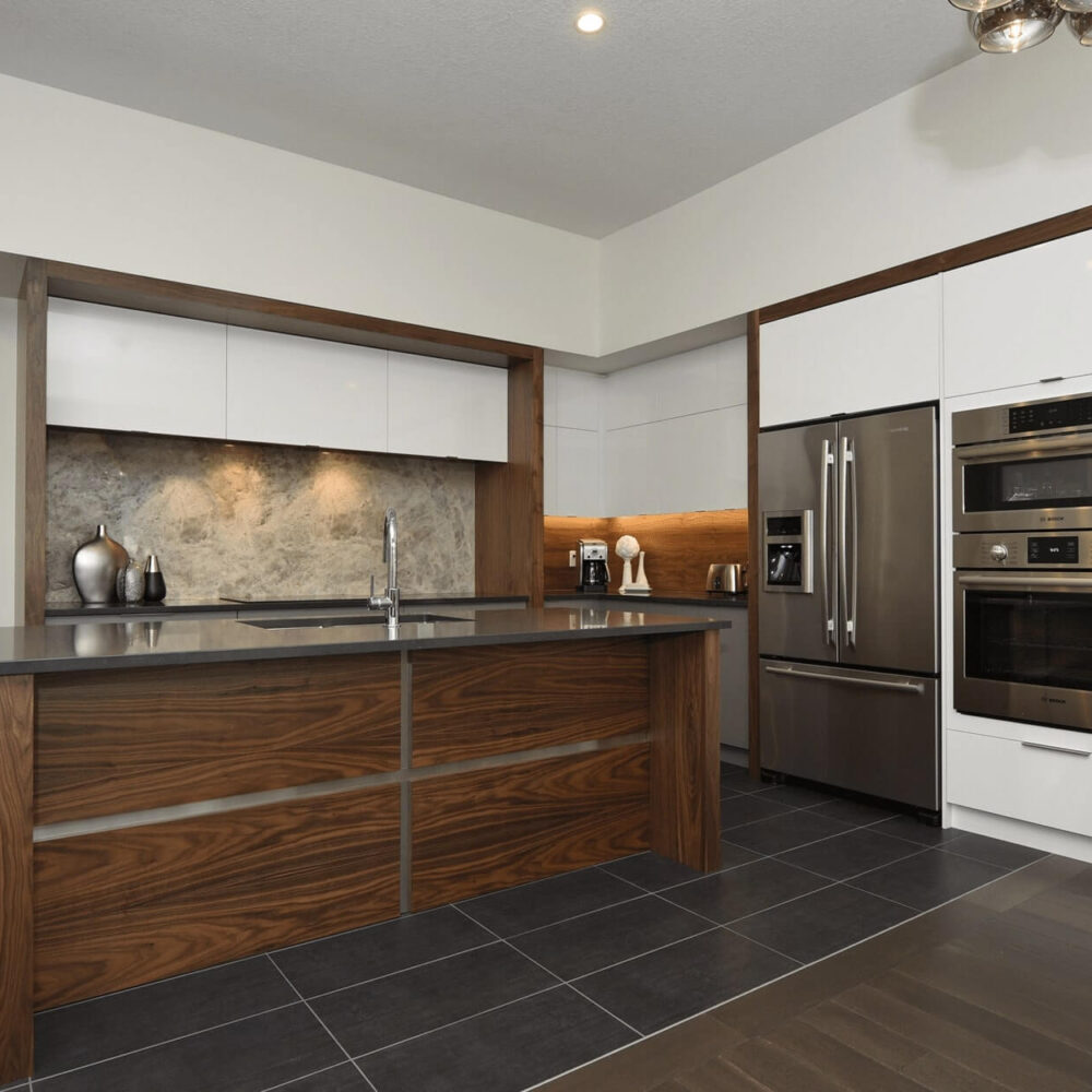Callingham kitchen by Casey's Kitchens with modern design, walnut wood accents, white high-gloss cabinets, stainless steel appliances, and a marble backsplash.