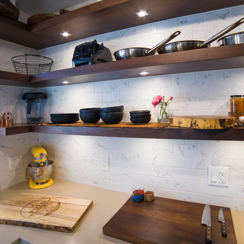 Old South Kitchen project by Casey's Kitchens featuring dark walnut open shelves, white subway tile backsplash, a bright yellow KitchenAid mixer, and black bowls with copper accents, Chad Stewart’s workspace vibe.