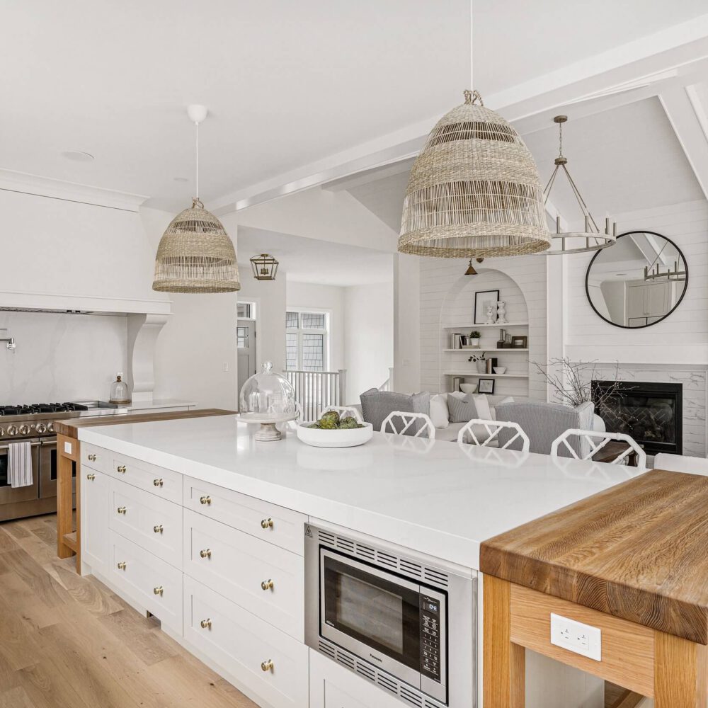 Contemporary kitchen featuring white cabinetry, wooden island, and pendant lighting with woven shades.
