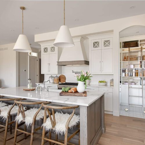 Byron Beauty kitchen by Casey's Kitchens with muted white cabinetry, oak accents, a marble island, and brass hardware in a modern French Country style, located in London, Ontario