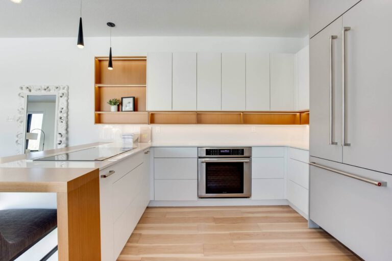 Modern kitchen design featuring white cabinetry, wooden accents, and stainless steel appliances with a clean, minimalist aesthetic.
