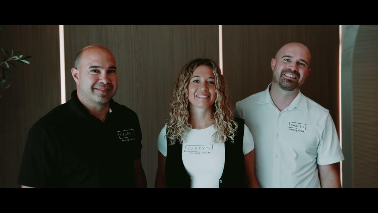 At Casey’s Kitchens Highlights, three team members stand together in branded shirts as the company shares client experiences and kitchen projects.